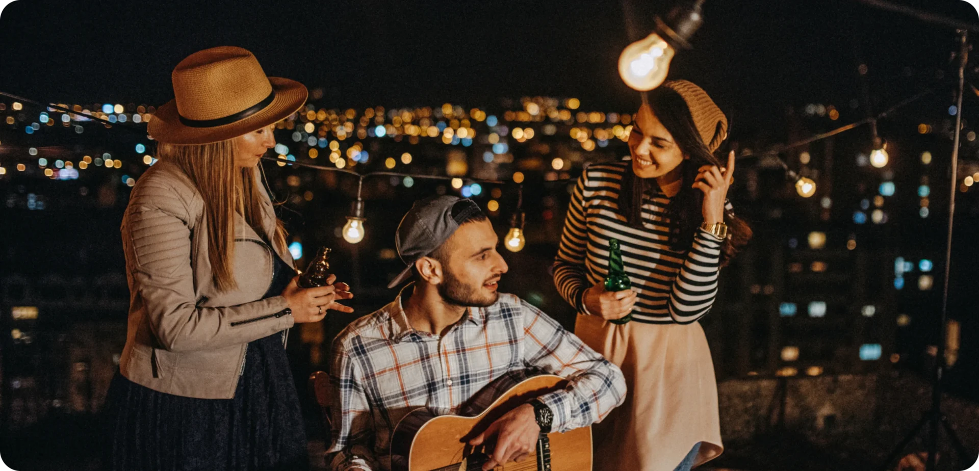 People socializing outdoors under string lights