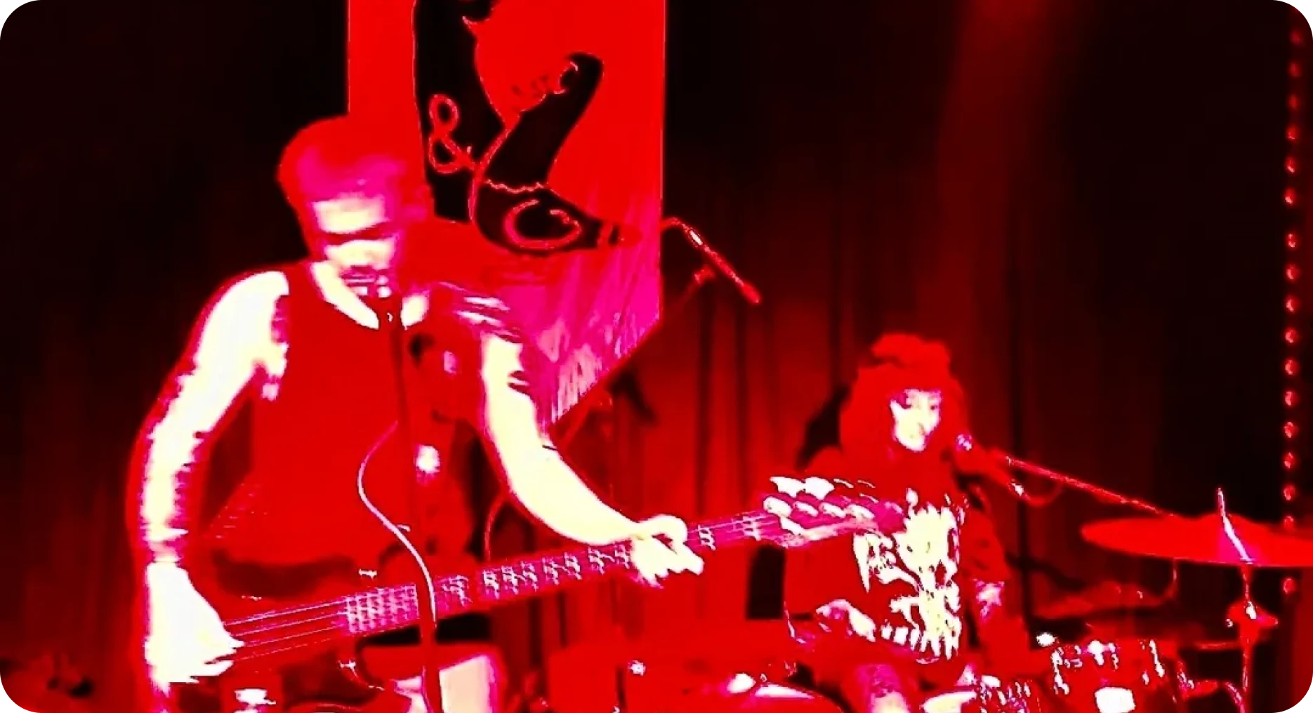 Band performing live with red lighting